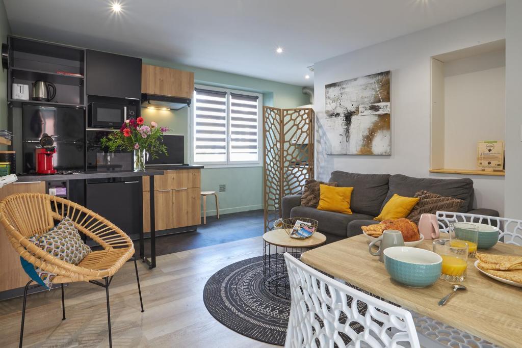 a living room and kitchen with a couch and a table at Centre ville à pied Appt avec SAUNA, Linge, Wifi, Stationnement Gratuit in Vannes