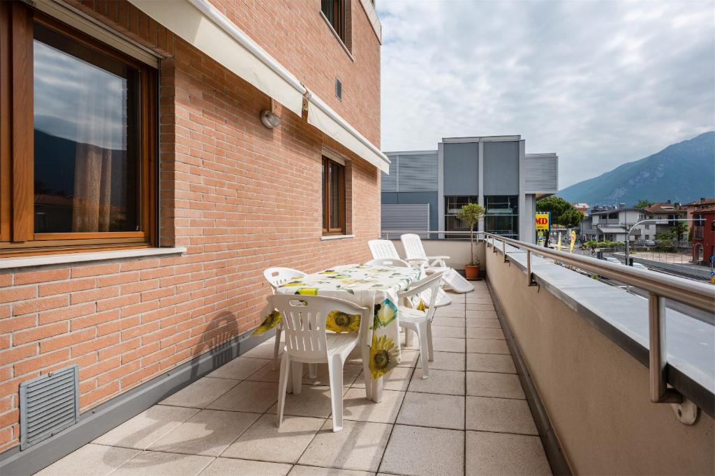 a balcony with a table and chairs on a building at Appartamento Le Vele in Riva del Garda