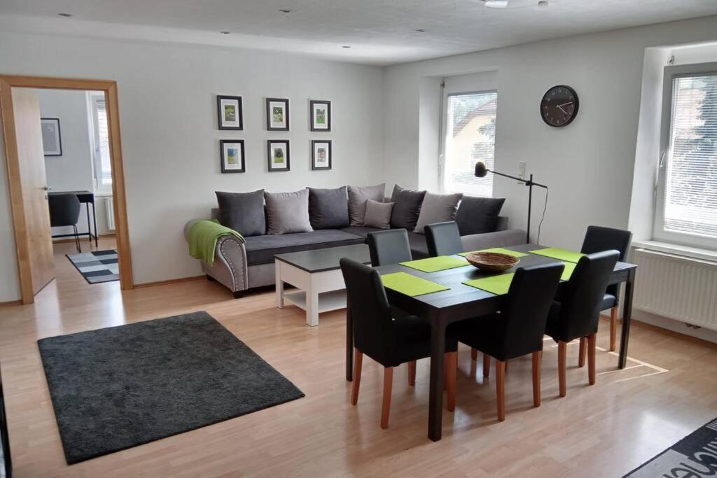 Gemütliches Apartment in Landeck في لاندك: غرفة معيشة مع أريكة وطاولة وكراسي