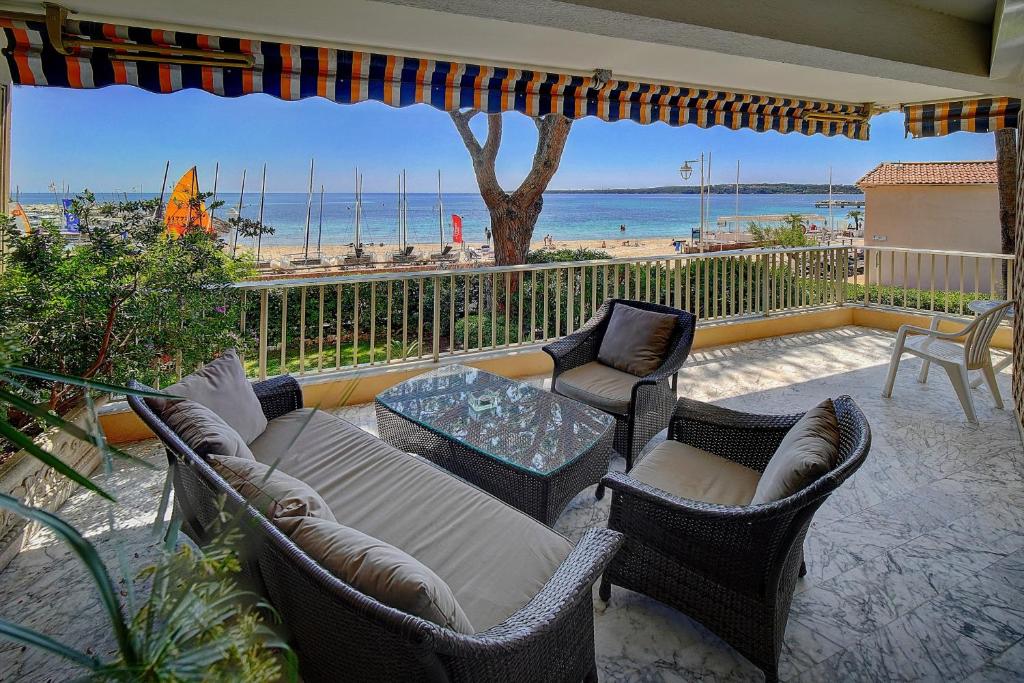 カンヌにあるIMMOGROOM- Huge Terrace - Panoramic Sea View - 1min from Beachのパティオ(ソファ、椅子付)、ビーチが備わります。