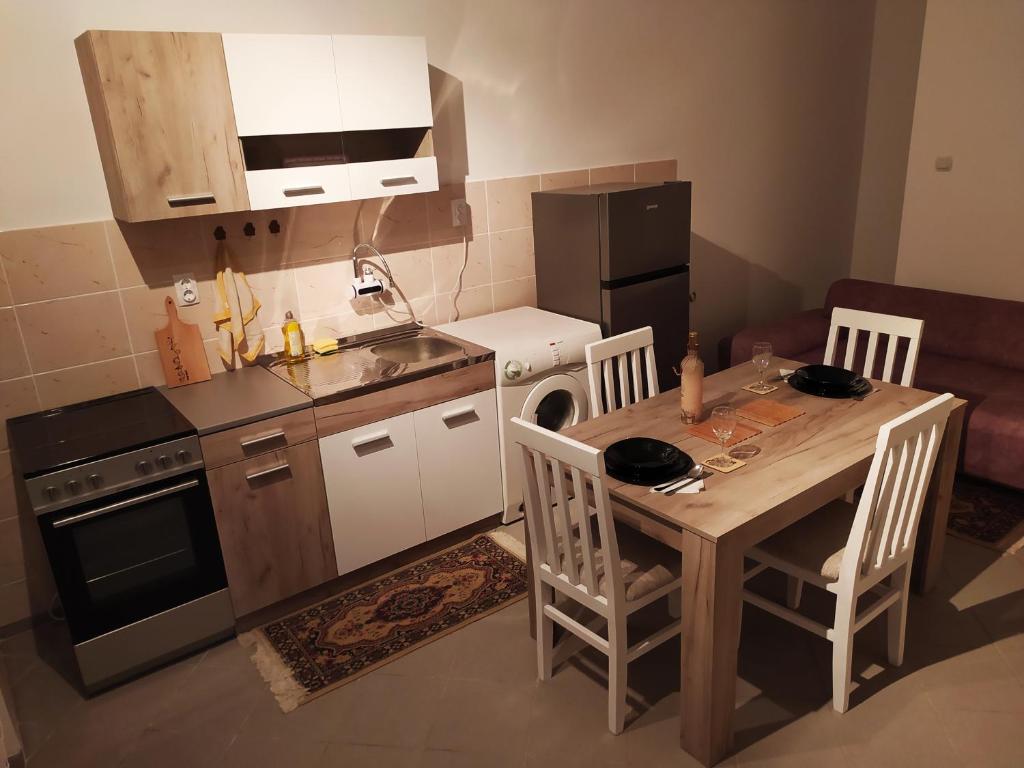 een kleine keuken met een tafel, een fornuis en een koelkast bij Apartman Todorovic in Jagodina