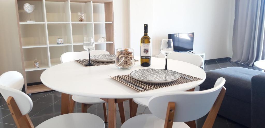 a white dining room table with a bottle of wine at KATHRIN APPARTS in Alepou