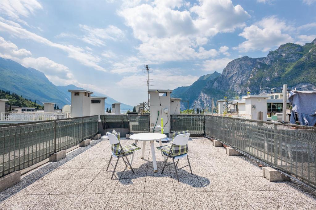 una mesa y sillas en un balcón con montañas en Brione paradise, en Riva del Garda