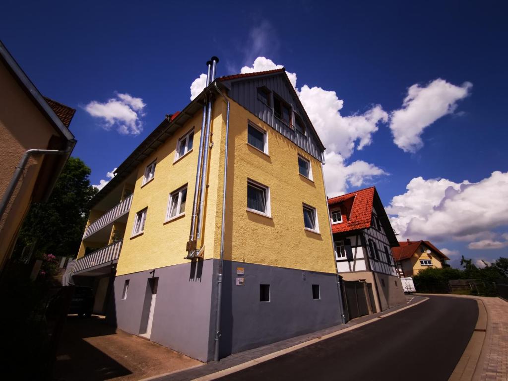 ein gelbes Gebäude an der Straßenseite in der Unterkunft Ferienwohnung Brigitte in Reichelsheim