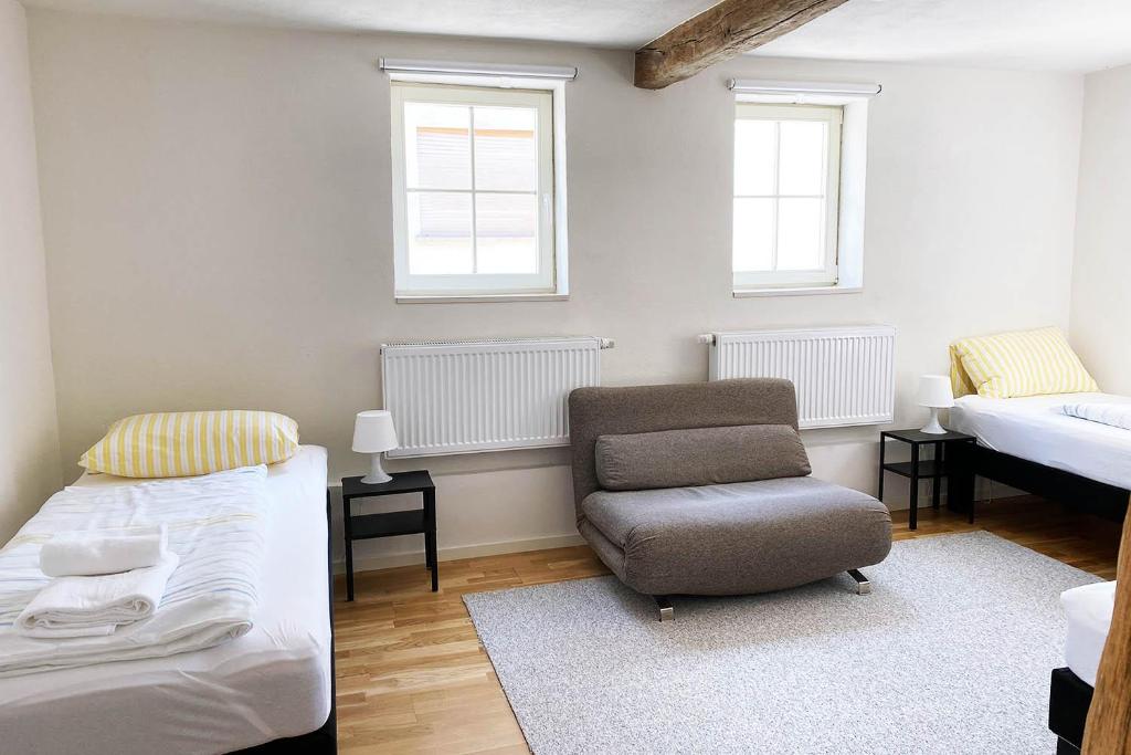 ein Schlafzimmer mit einem Bett und einem Stuhl darin in der Unterkunft Charmante Apartments mit TV-WiFi in Kelkheim