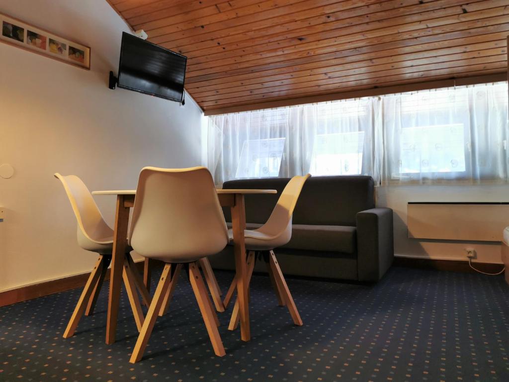a room with a table and chairs and a couch at Apartma Svizec Rogla in Zreče