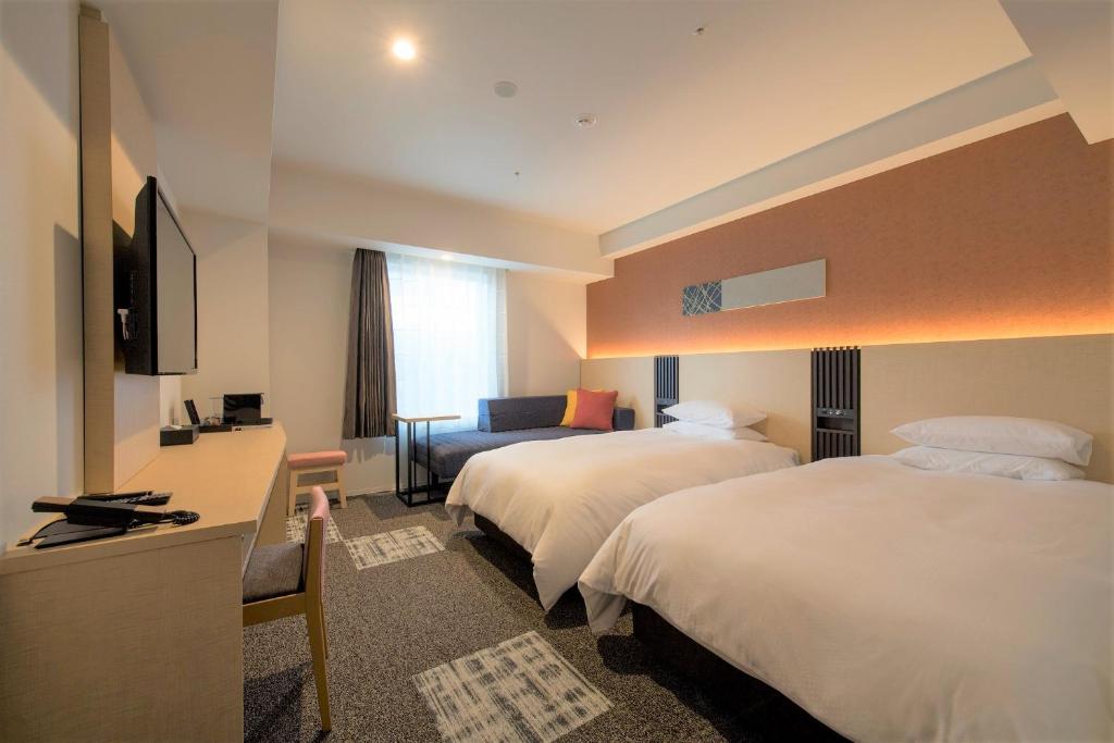 a hotel room with two beds and a television at Tmark City Hotel Sapporo Odori in Sapporo