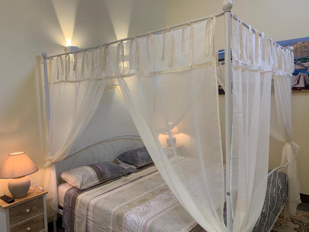 una camera con letto a baldacchino e tende bianche di Piazza Fontana Luxury a Galatina