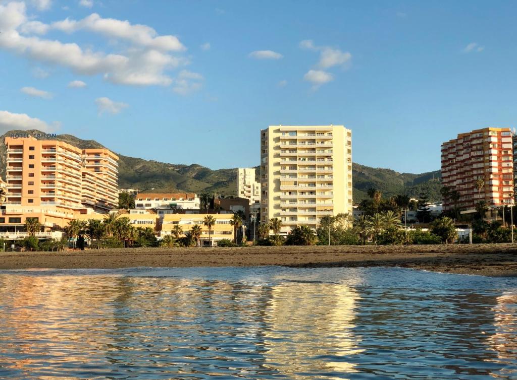 een uitzicht op het strand met gebouwen op de achtergrond bij JSM Apartamentos in Benalmádena