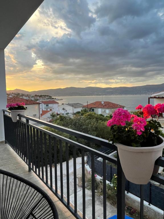 a balcony with a view of the ocean and flowers at Blue Sky Apartments in Slatine