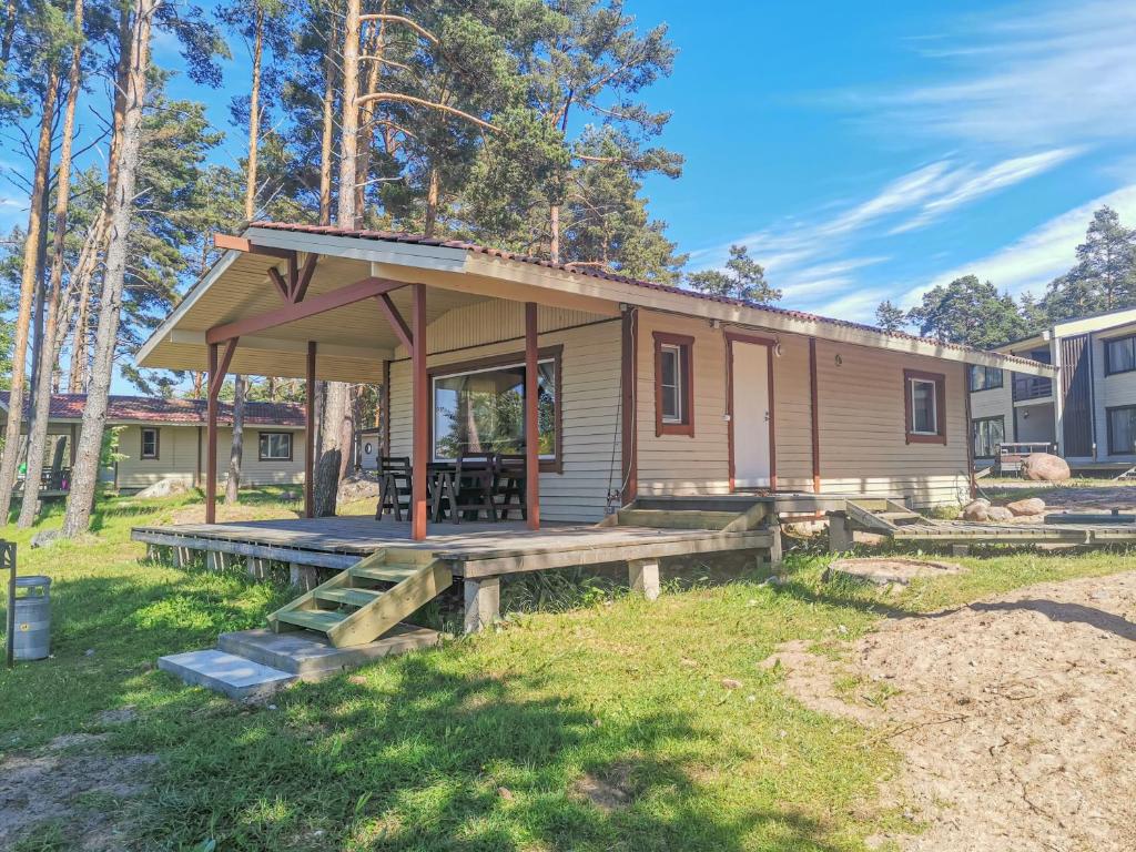 a tiny house with a porch and a deck at Okunevaya Holiday Park in Ozerki