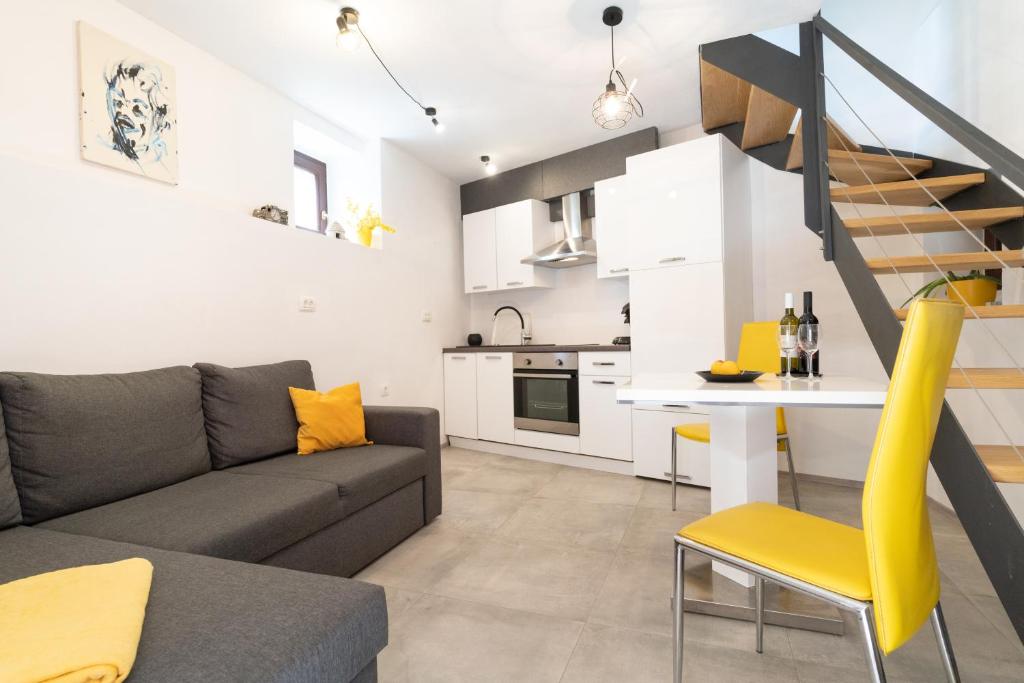 a living room and kitchen with a couch and a table at Apartment Juraj in Rovinj