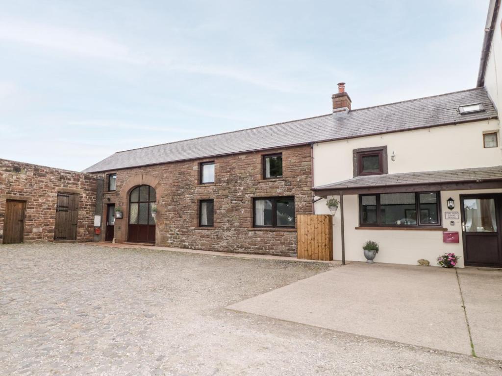 an old brick house with a large driveway at The Old Cook House in Penrith