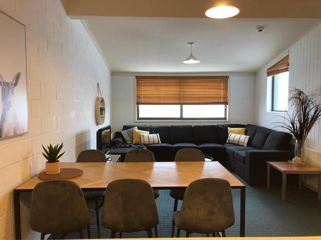a living room with a couch and a table and chairs at Alpine Cabin- Spa/Pool/Sauna in Mount Hotham