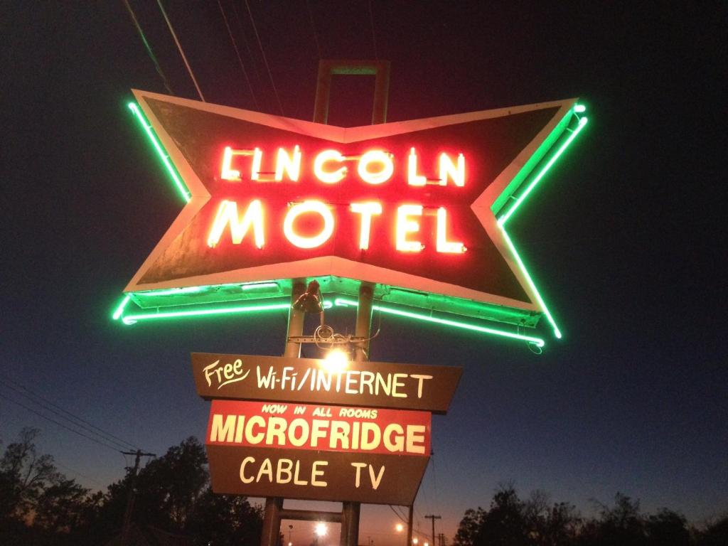
a neon sign that is on top of a lamp post at Lincoln Motel in Chandler
