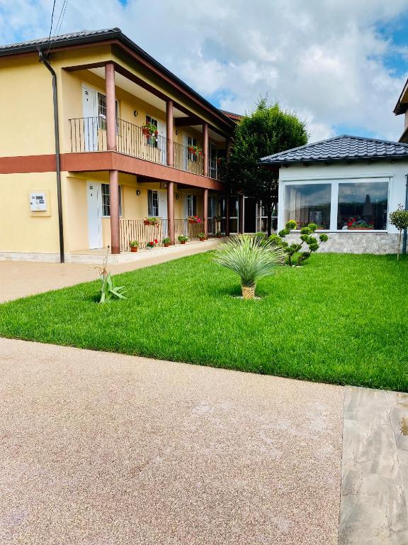 a house with a green lawn in front of it at Casa Eva in 2 Mai