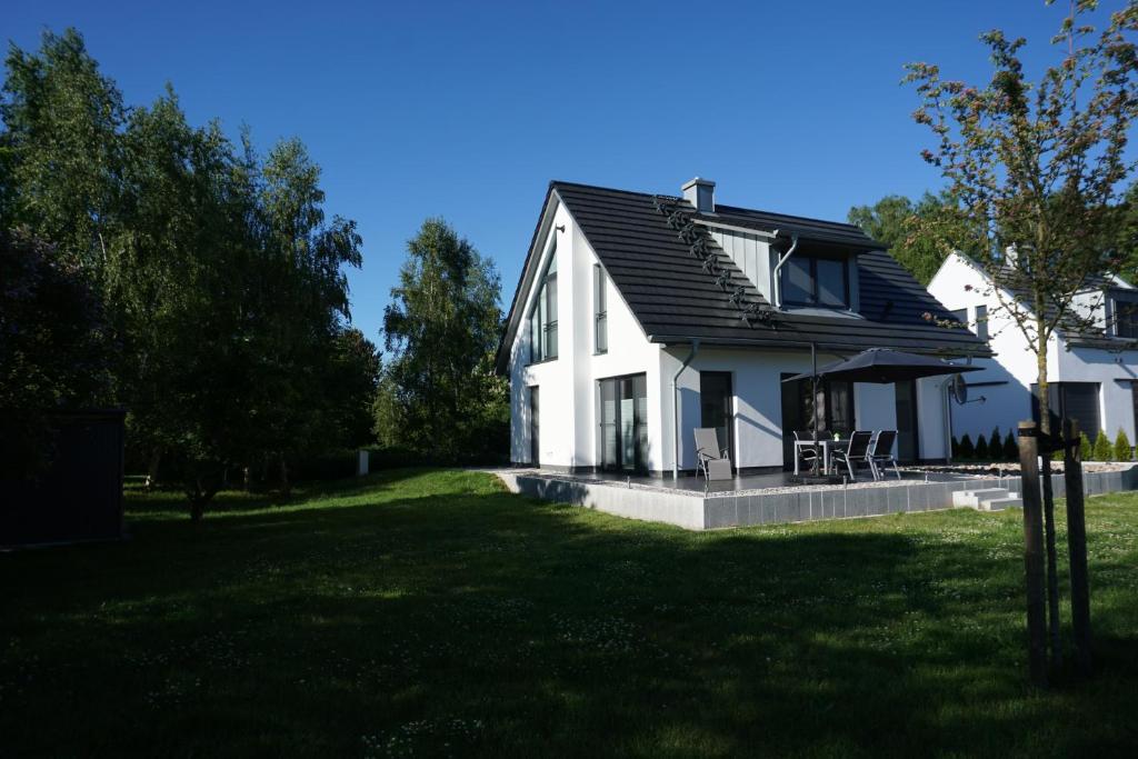a white house with a black roof at Ferienhaus Marny in Trassenheide