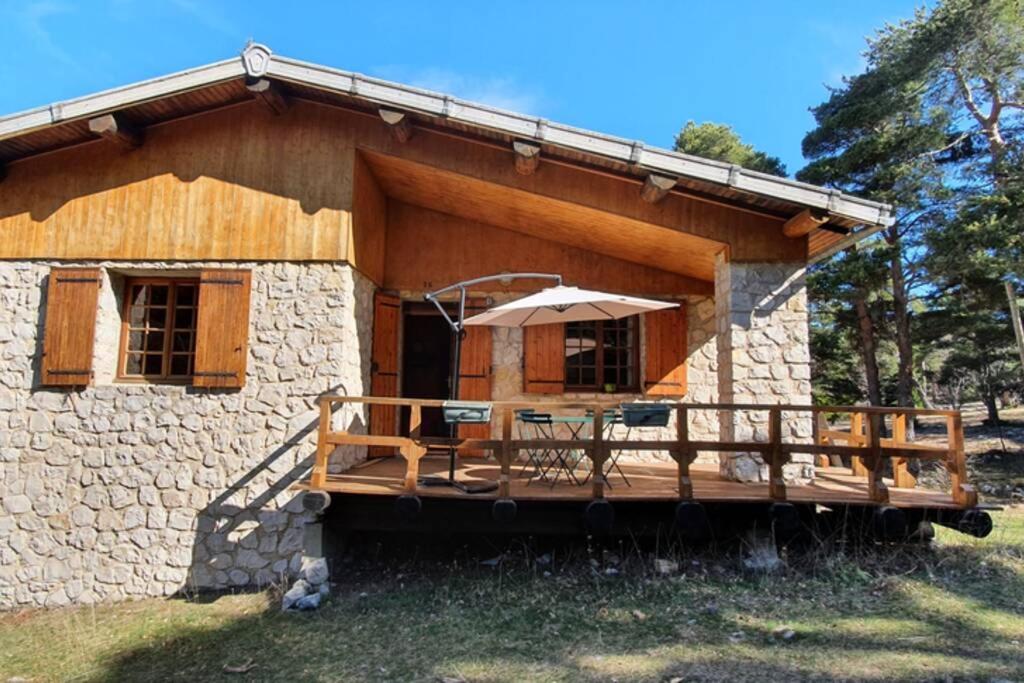 uma cabana de madeira com um alpendre e um deque em Chalet privé au Mont-Serein ventoux em Mont Serein