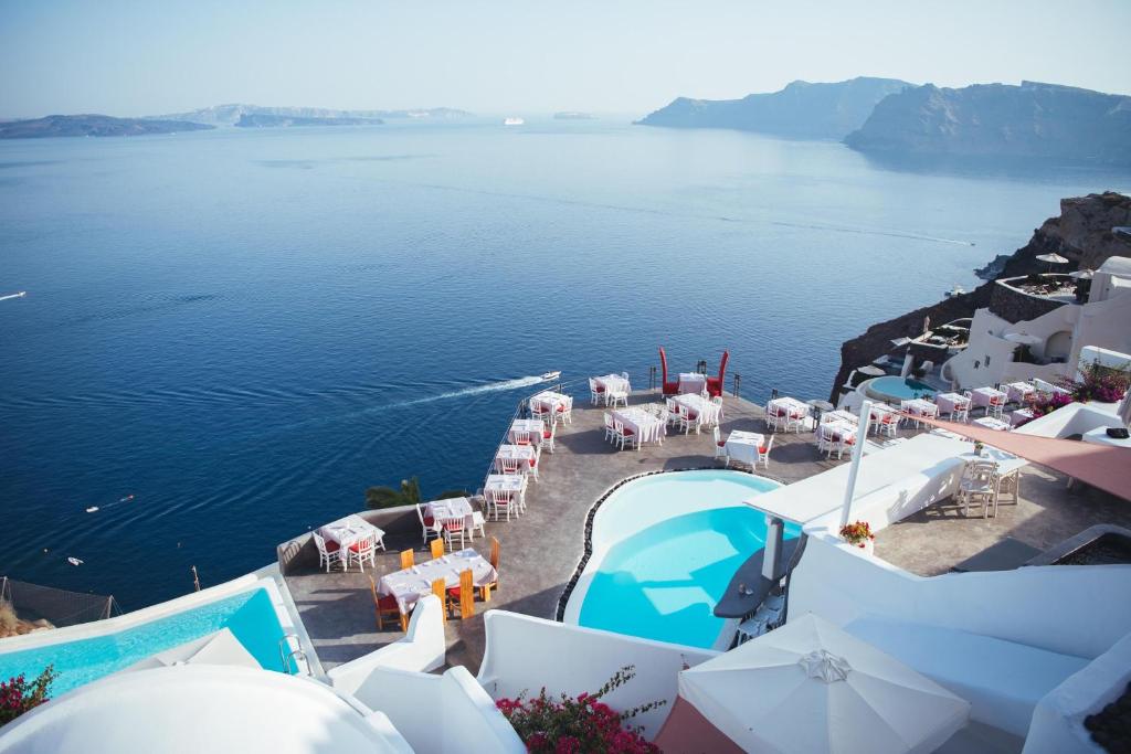 an aerial view of the water with tables and chairs at Andronis Boutique Hotel in Oia