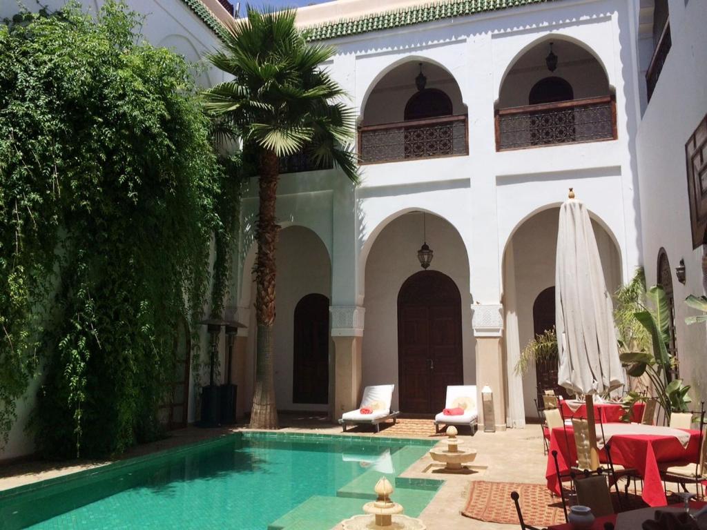 einen Innenhof mit einem Pool und einem Gebäude in der Unterkunft Riad Shama Suites & Spa in Marrakesch