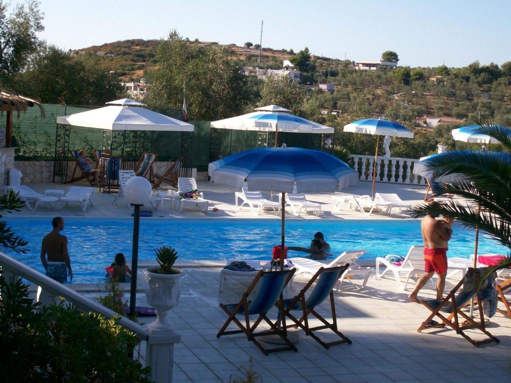 維耶斯泰的住宿－阿爾泰雅鄉村公寓酒店，游泳池配有椅子和遮阳伞,周围的人可以坐在游泳池周围