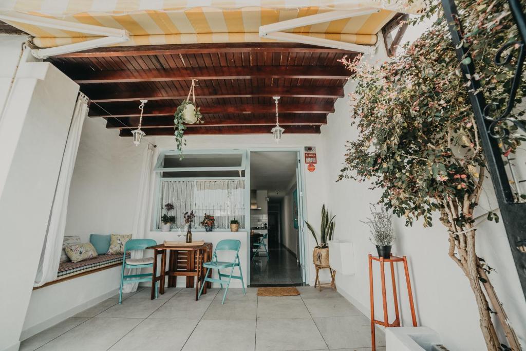 Casa Ola في بويرتو ديل كارمن: غرفة معيشة بسقف خشبي وطاولة وكراسي