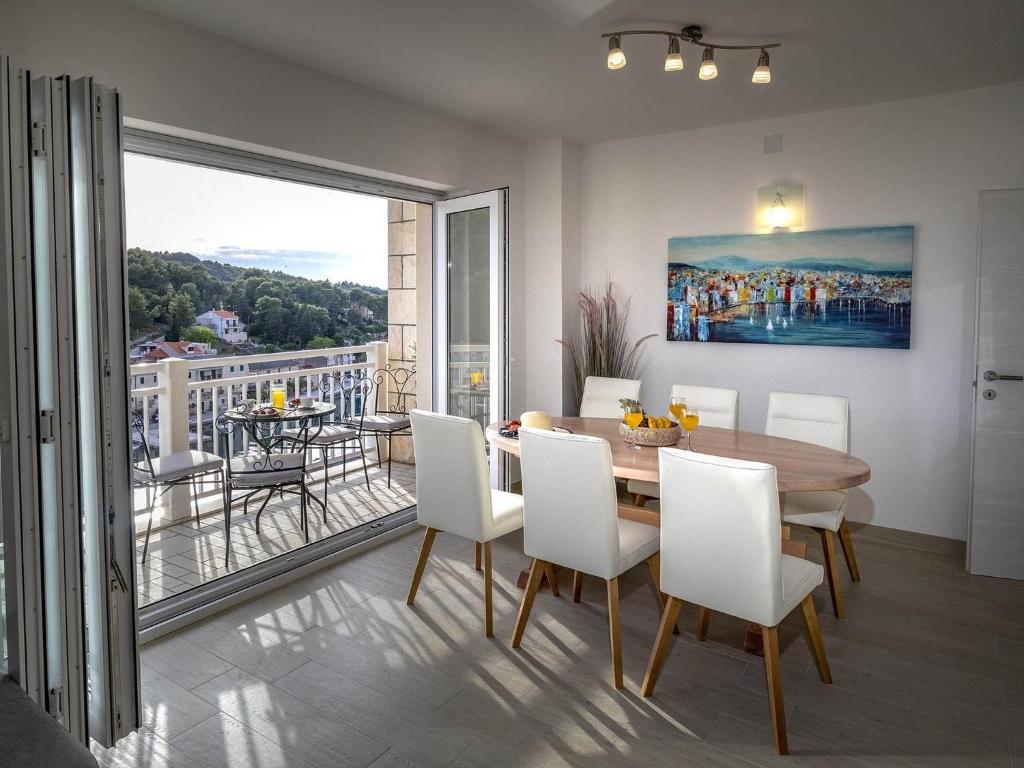 a dining room with a table and chairs and a balcony at Apartments Snjezana in Povlja