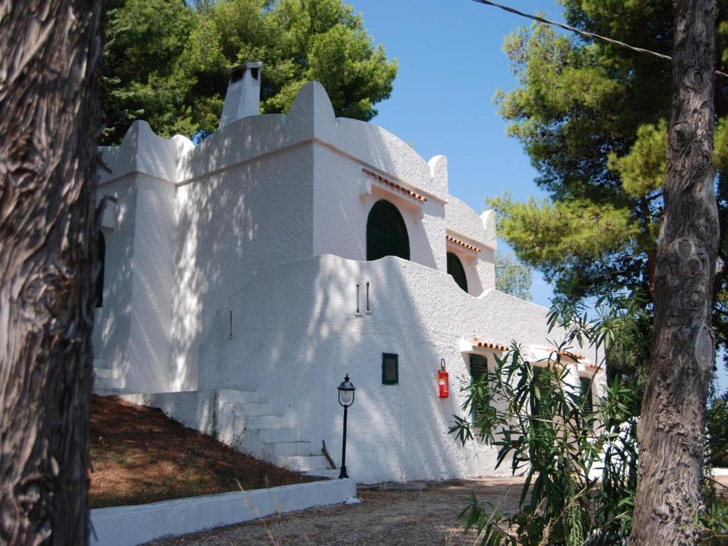 a white building with trees in front of it at Althea Village Residence in Vieste