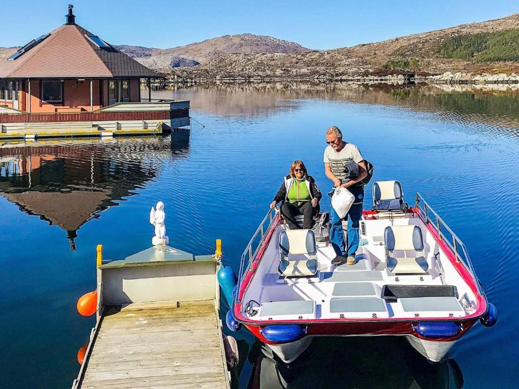 mężczyzna i kobieta na łodzi w doku w obiekcie Two-Bedroom Holiday home in Kalvåg w mieście Kalvåg