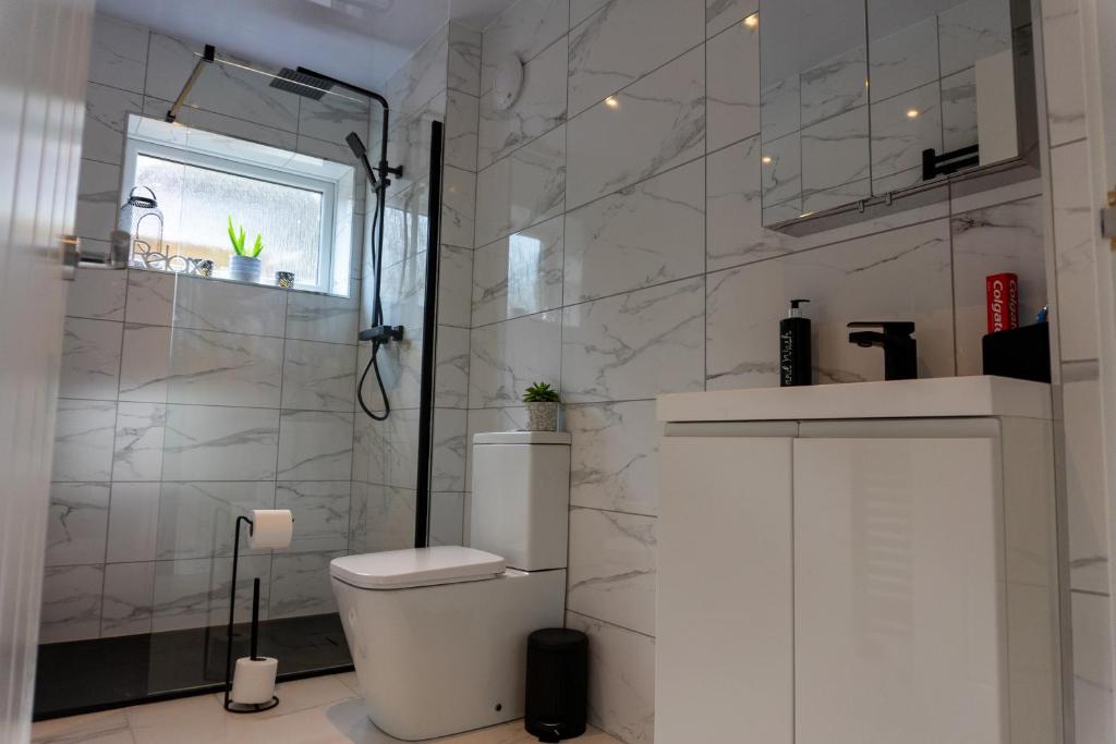 a white bathroom with a toilet and a shower at Stunning one bedroom accommodation in Oban