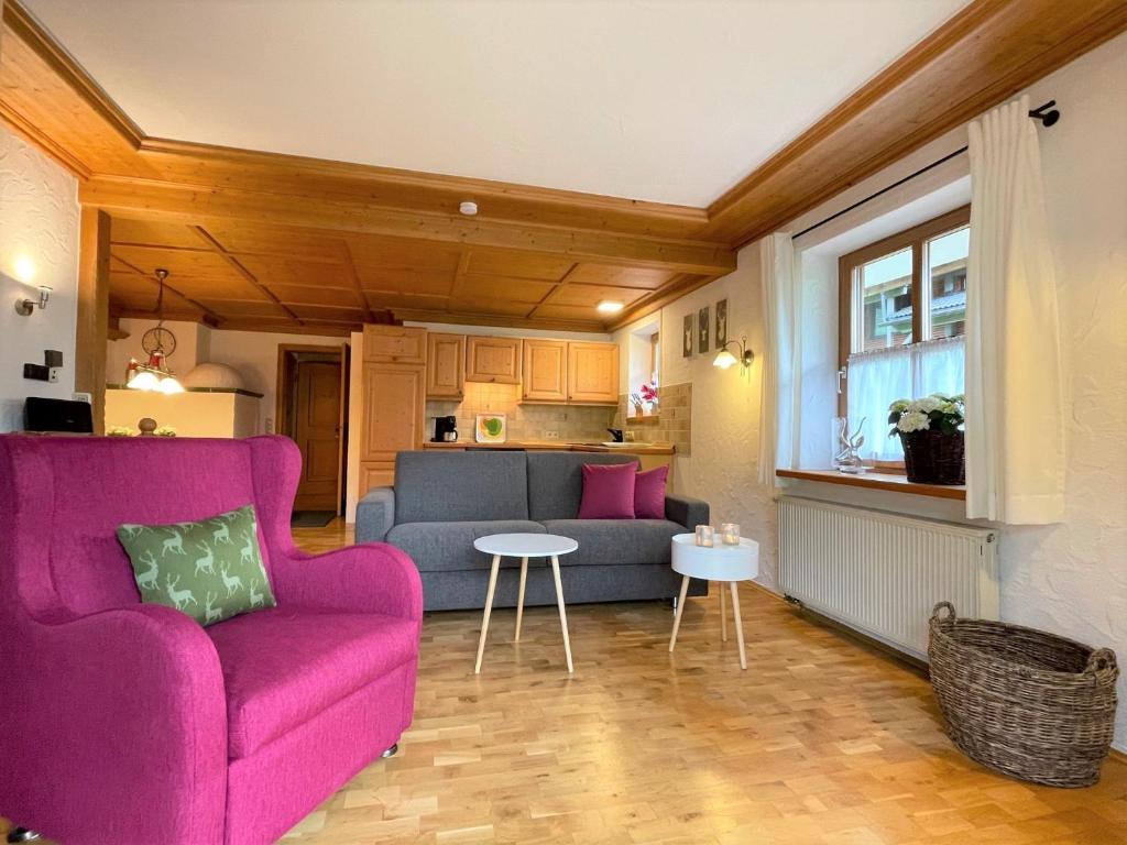 a living room with a purple couch and a table at Ferienwohnungen Alpentraum - Tiefengrün und Tiefenblau in Oberstdorf