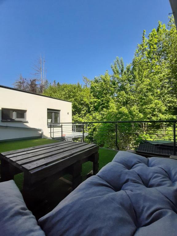 un patio con una mesa de picnic de madera y un banco en Waldurlaub Klingelborn im Sauerland en Balve