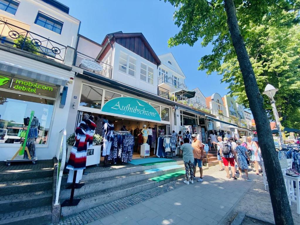 een groep mensen die voor een winkel lopen bij Sonnenschein, direkt am Alten Strom in Warnemünde