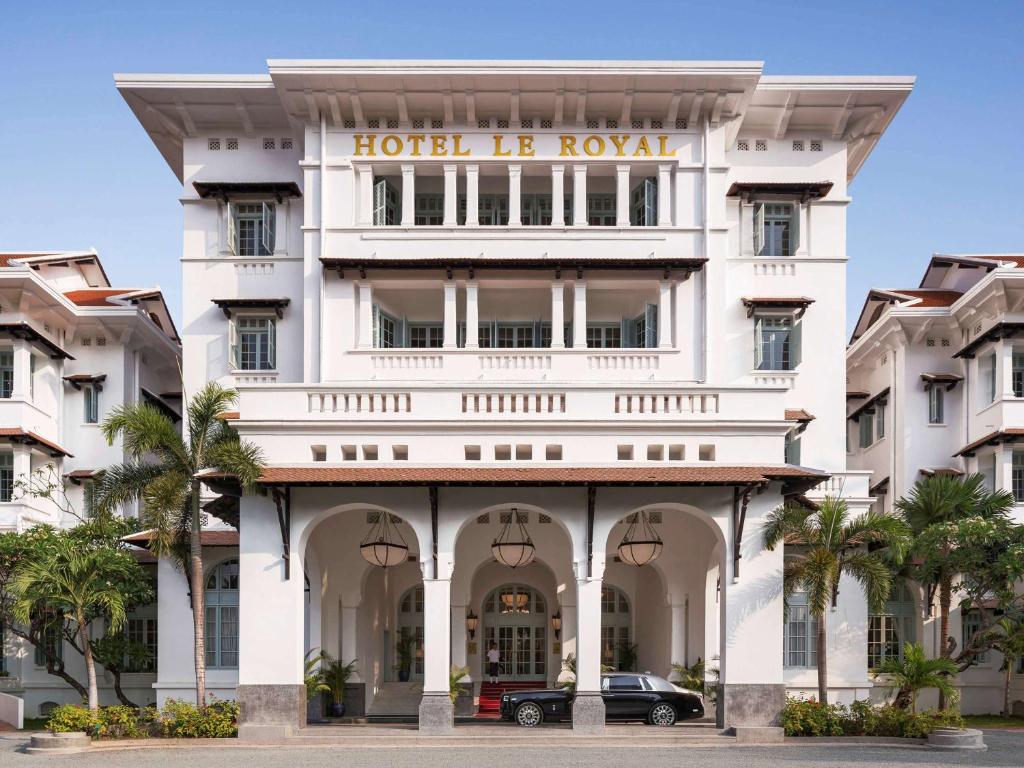 a hotel is royal with a car parker front in der Unterkunft Raffles Hotel Le Royal in Phnom Penh