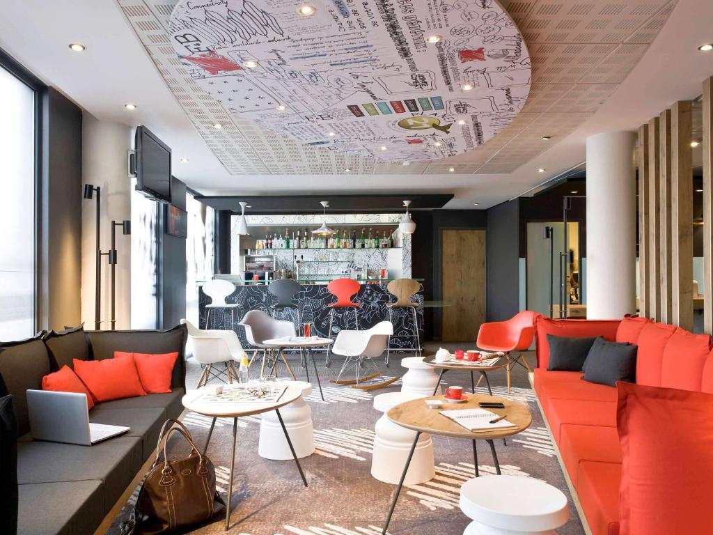 une salle avec des canapés et des tables ainsi qu'un bar dans l'établissement ibis Bordeaux Centre - Gare Saint-Jean, à Bordeaux