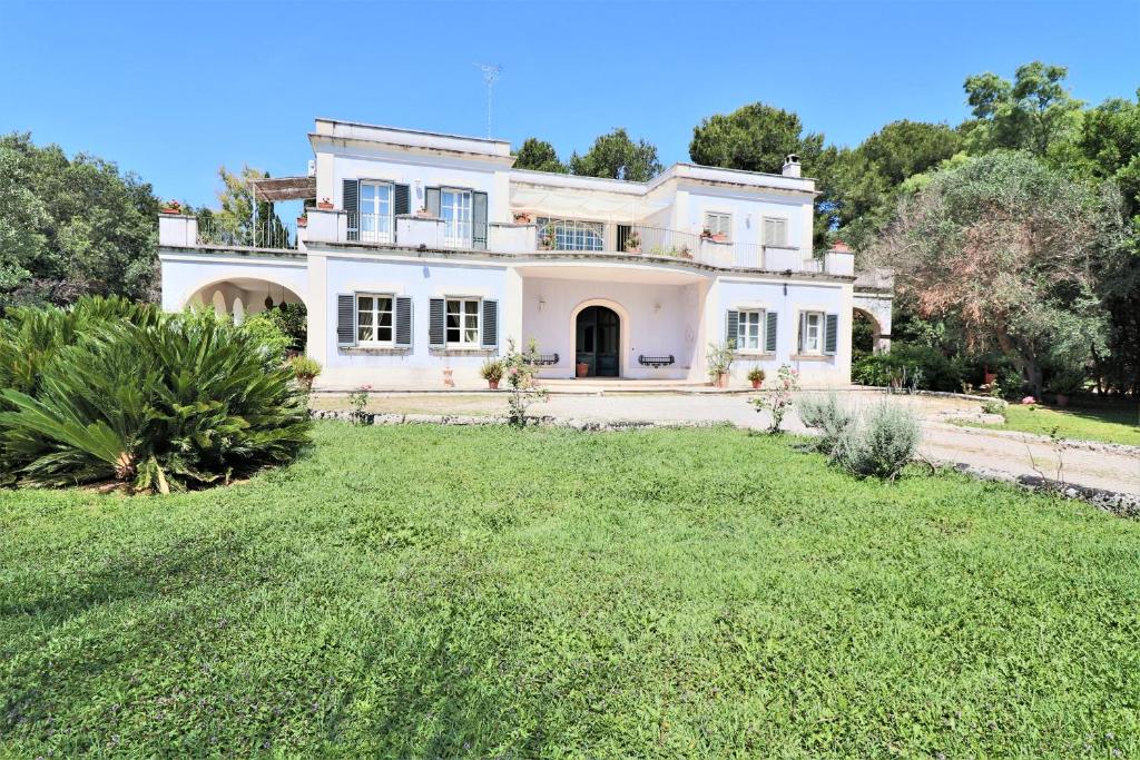 a large white house with a yard at Relais Delle Rose in Lecce