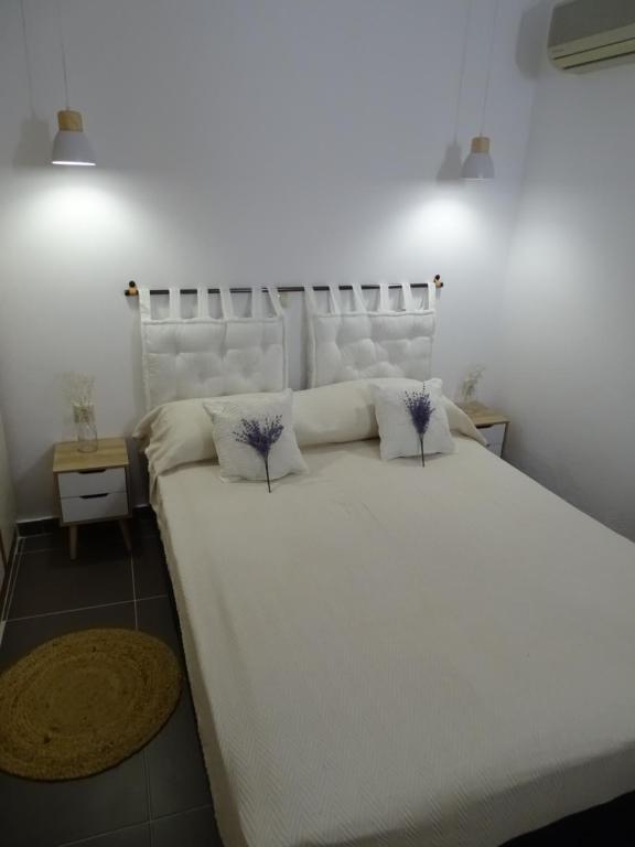 sypialnia z dużym białym łóżkiem z 2 poduszkami w obiekcie D&D apartments w mieście Epidauros