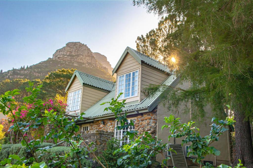 a stone house with a mountain in the background at Houtkapperspoort Mountain Cottages in Cape Town
