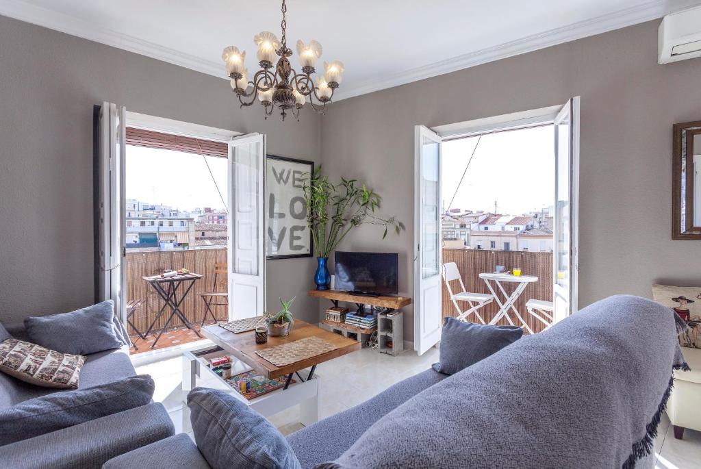 a living room with a couch and a living room with a balcony at Apartment Ruzafa Market I in Valencia