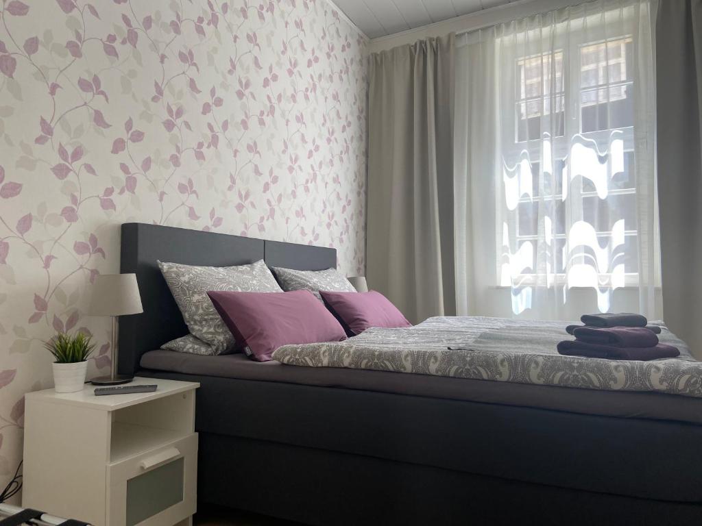 - une chambre avec un lit et une fenêtre ornée de fleurs roses dans l'établissement Apartment In der Hohen, à Quedlinbourg