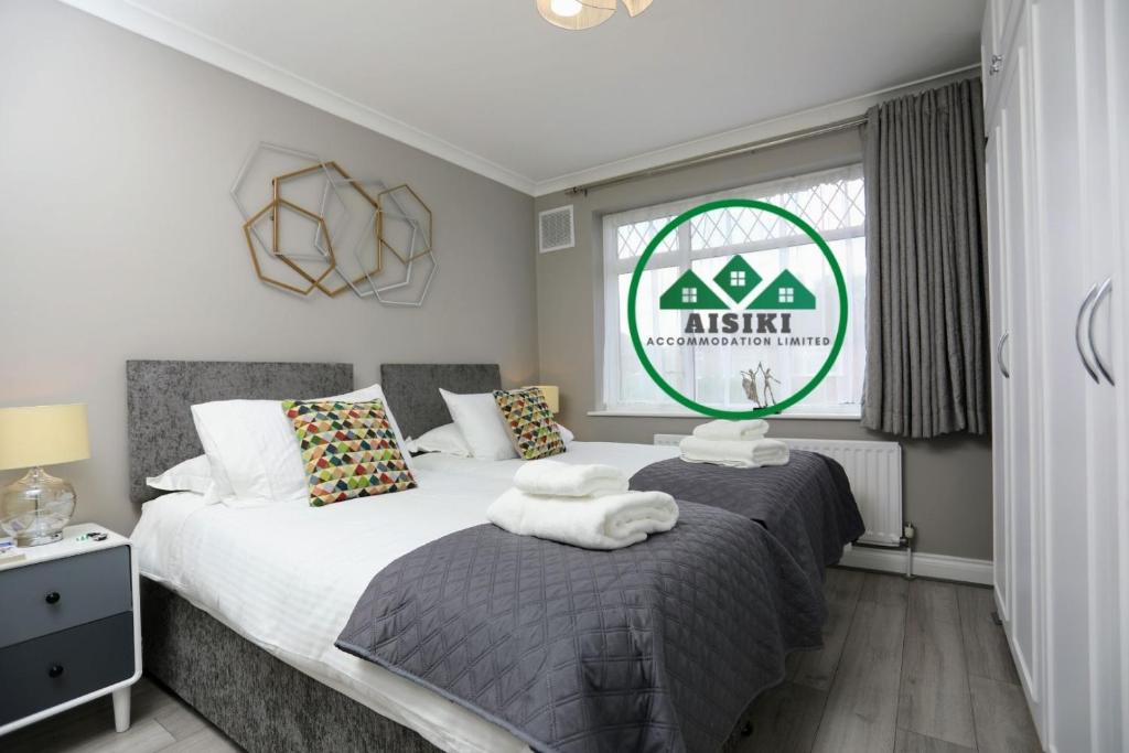 a bedroom with two beds and a window at FW Haute Apartments at Hillingdon, 3 Bedrooms and 2 Bathrooms Pet-Friendly HOUSE with Garden, with King or Twin beds with FREE WIFI and PARKING in Hillingdon