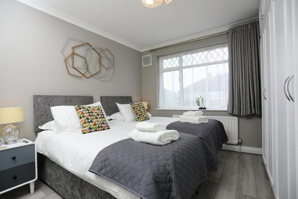 a bedroom with two beds and a window at FW Haute Apartments at Hillingdon, 3 Bedrooms and 2 Bathrooms Pet-Friendly HOUSE with Garden, with King or Twin beds with FREE WIFI and PARKING in Hillingdon