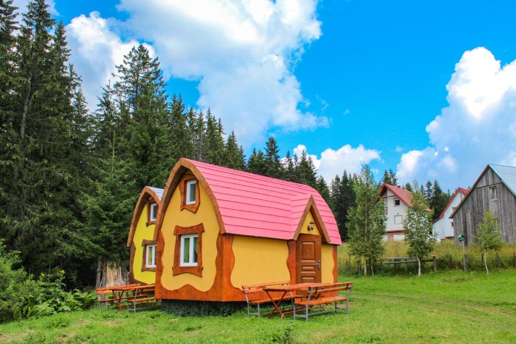 ein kleines Haus mit rotem Dach auf einem Feld in der Unterkunft Bungalows Fairy tale in Žabljak