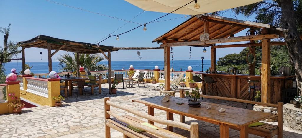 a patio with tables and chairs and the ocean at Pelekas Beach Apartments in Pelekas