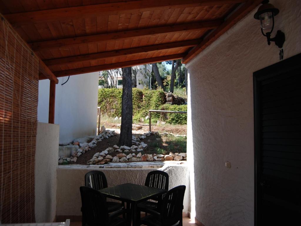 a patio with a table and chairs in a house at Althea Village Residence in Vieste