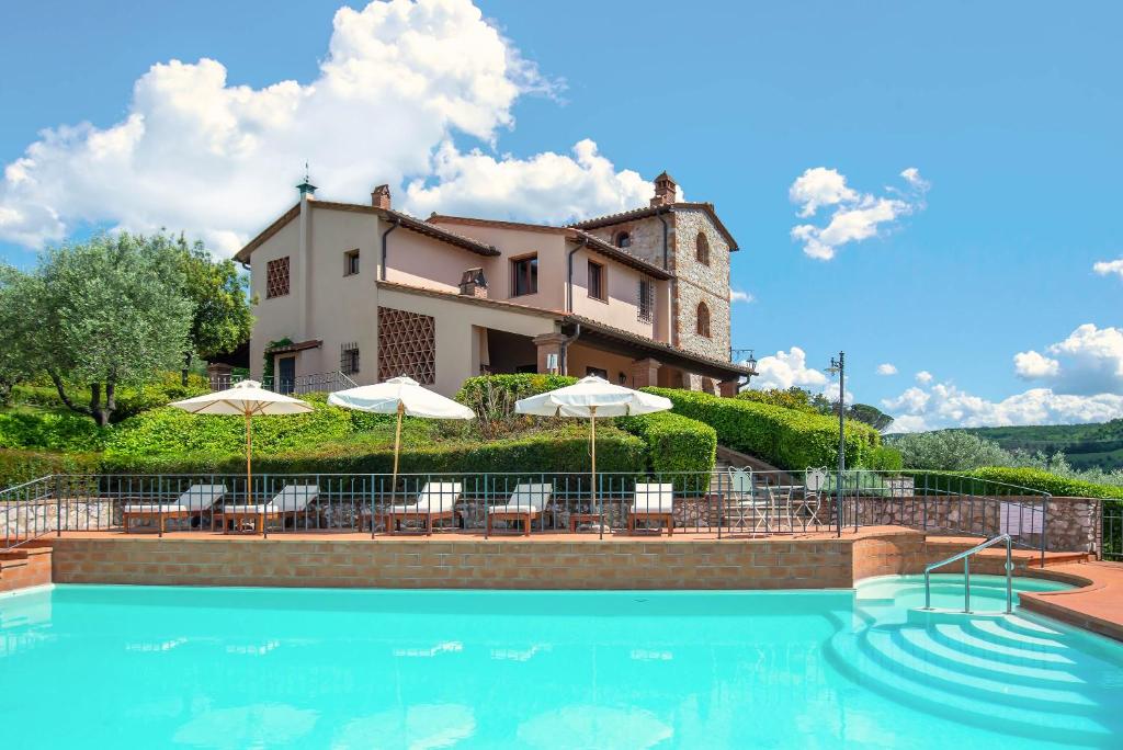 a villa with a swimming pool in front of a house at Villa Lionella Country Resort in Montaione