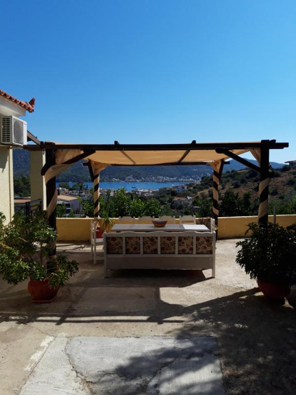 a wooden gazebo with a table on a patio at Elaia country living in Galatas