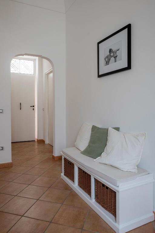 ein weißes Zimmer mit einem weißen Sofa und einer Tür in der Unterkunft Due Passi in Capri
