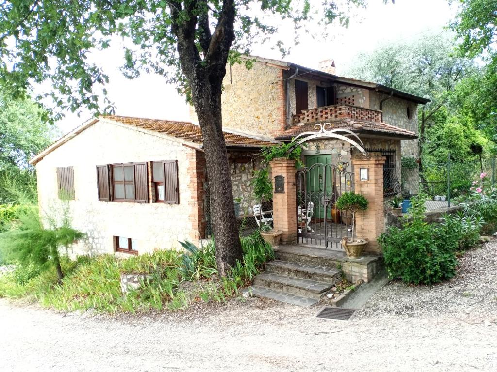 una casa de ladrillo con una puerta verde y escaleras en Tra grilli e cicale, en Deruta