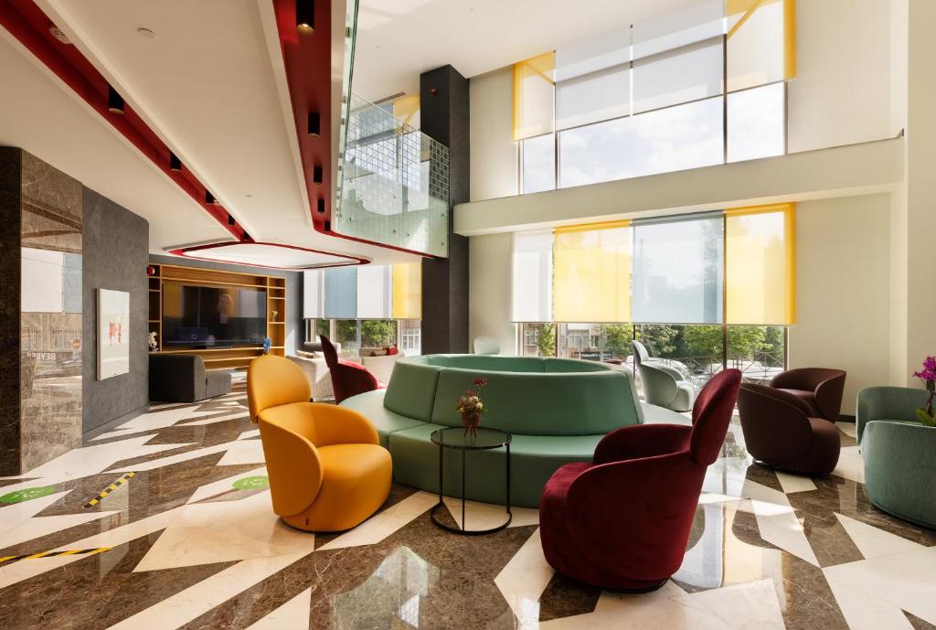 eine Lobby mit grünem Sofa und Stühlen in der Unterkunft ibis Styles Istanbul Merter in Istanbul